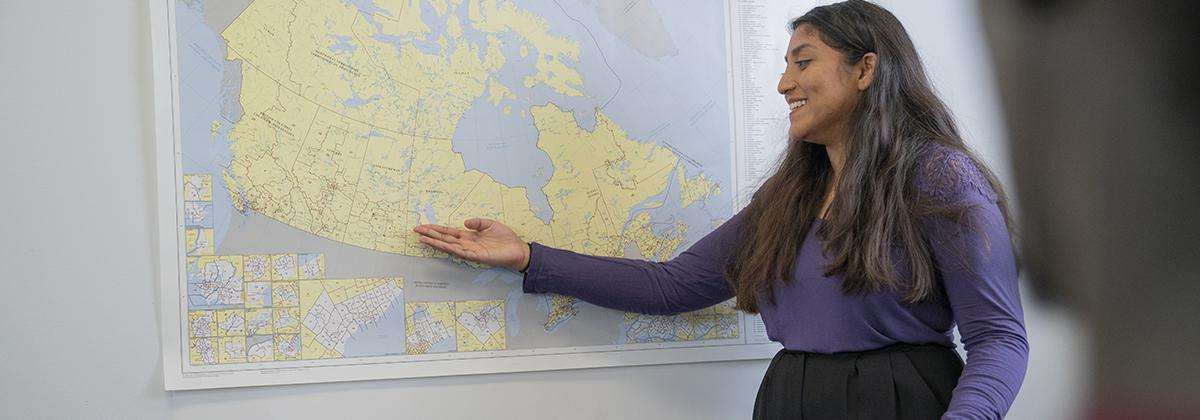 Une enseignante présente une grande carte du Canada.