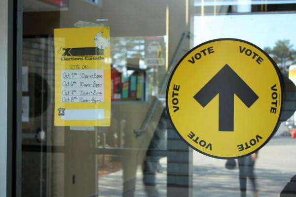 Deux autocollants de renseignements sur le vote collés sur une vitre.