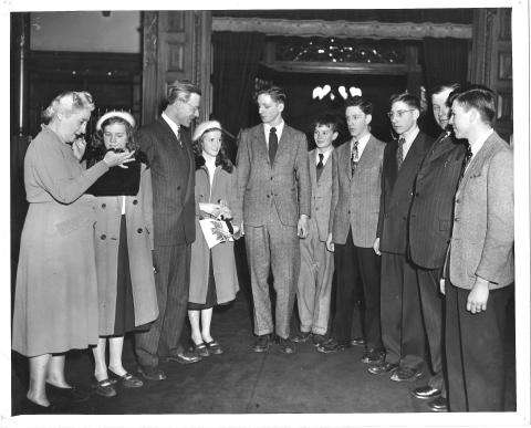 Photographie en noir et blanc d’un groupe de jeunes debout entourant Agnes Macphail.