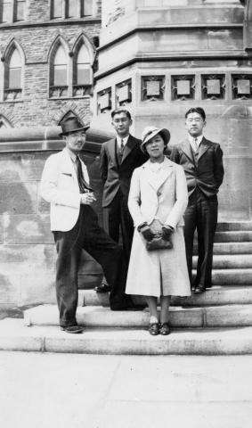 Photographie en noir et blanc d’un groupe de quatre femmes et hommes japonais debout sur les marches du Parlement.