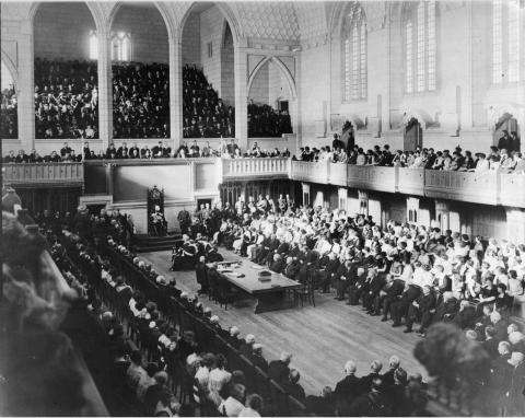 Photographie en noir et blanc de la Chambre des communes du Canada, comble lors de la cérémonie d’ouverture.