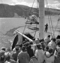 VRTT_Inuit_1962_FR Photographie en noir et blanc d'un groupe d'Inuits qui regarde un hélicoptère décoller à Salluit, Nunavik, Québec.