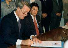 CE42-Japanese_FR Le premier ministre Brian Mulroney signe un document officiel.