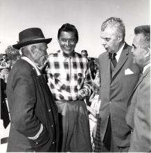 VRTT_FNP_1960_FR Photographie en noir et blanc de John Diefenbaker, du chef Brono, du chef Joe Sangris et du maire de Yellowknife (Territoires du Nord-Ouest). Les quatre sont debout et discutent.